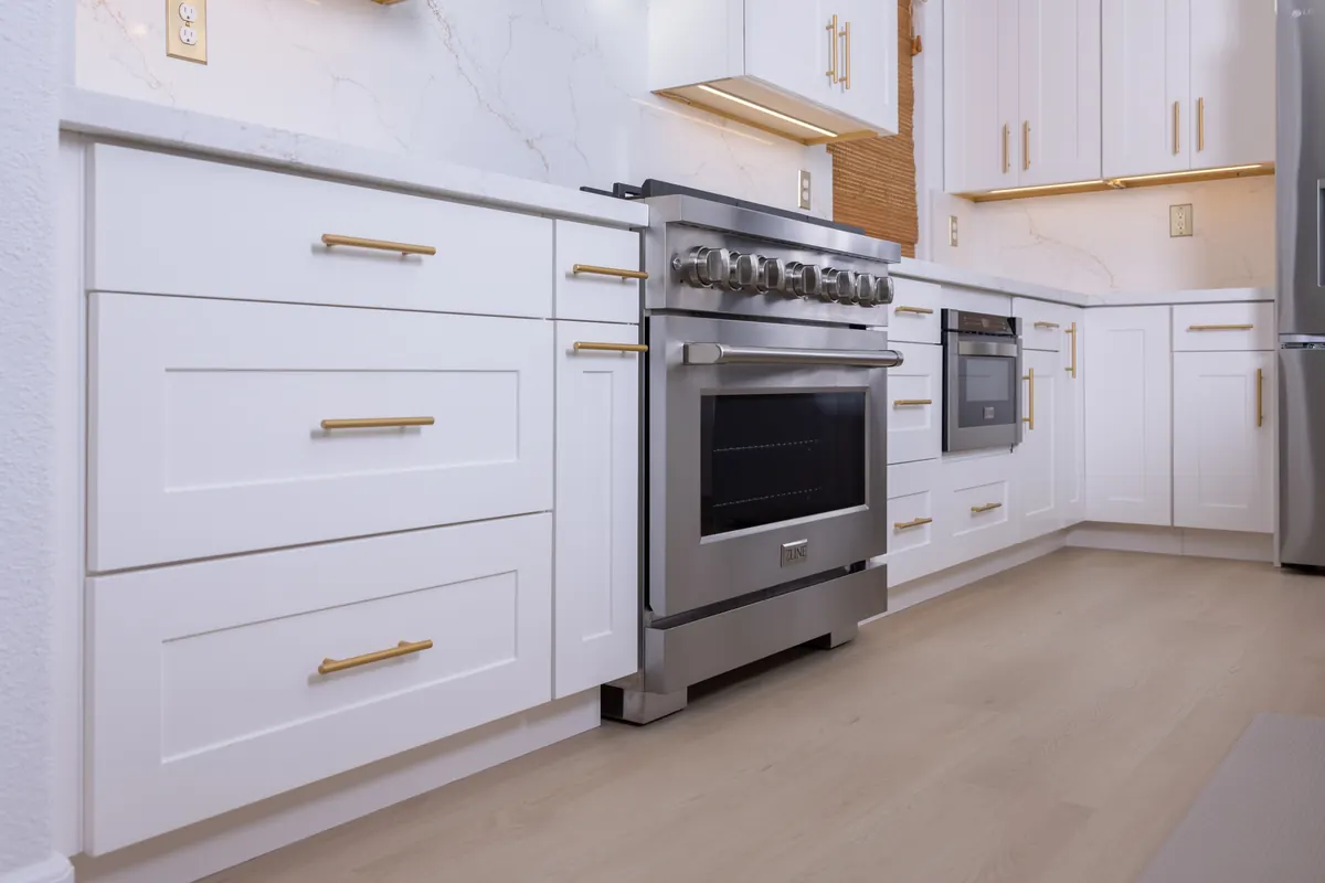 Quartz countertop and white cabinet detail with stainless range