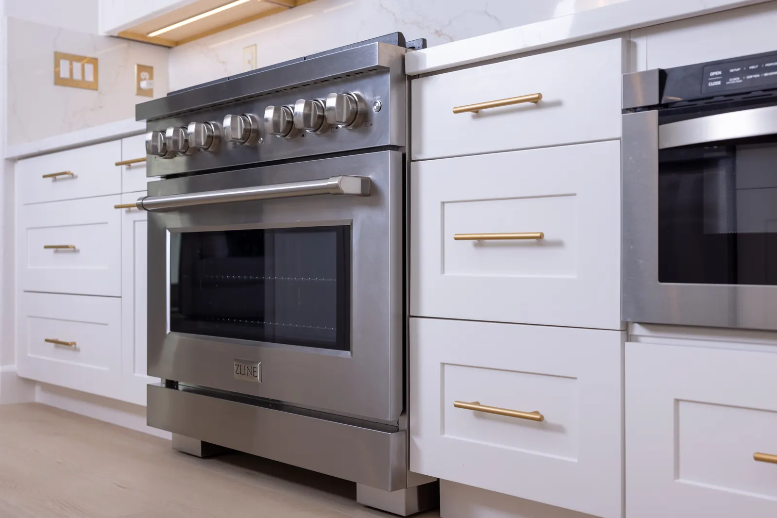 Close detail of range and white shaker drawers